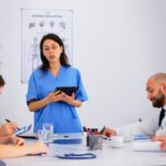 Doctors and nurses discussing a Medical Management Program in a hospital meeting room.