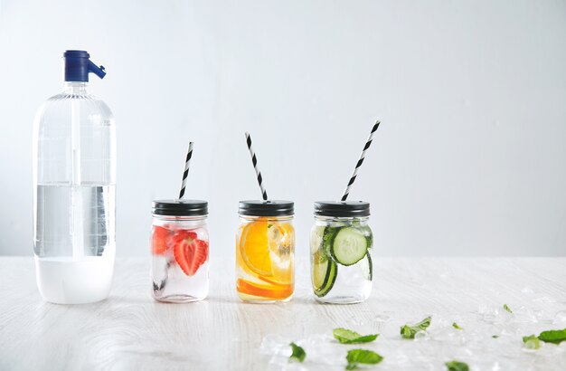 Best Zero Calorie Drinks in mason jars with strawberries, oranges, cucumbers, and a soda bottle.