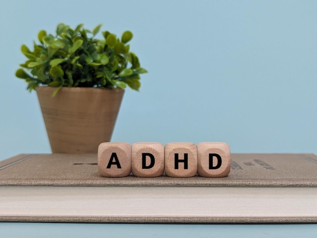 Wooden blocks spelling "ADHD" on a book, raising the question: Can a Primary Care Physician Prescribe Adderall?